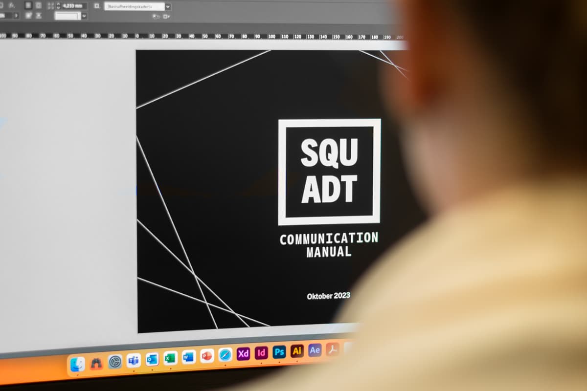 Persoon kijkt naar scherm naar een brandbook of huisstijlhandboek